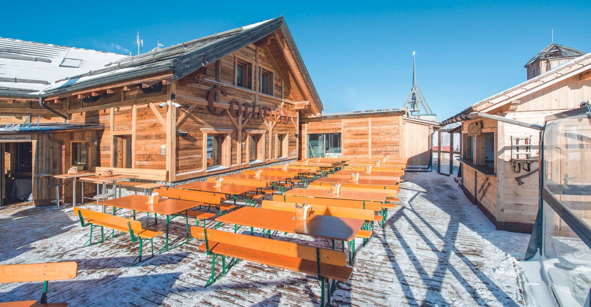 Wide beer garden table sets stand on the terrace of the cottage in winter. Wide beer garden table sets in winter