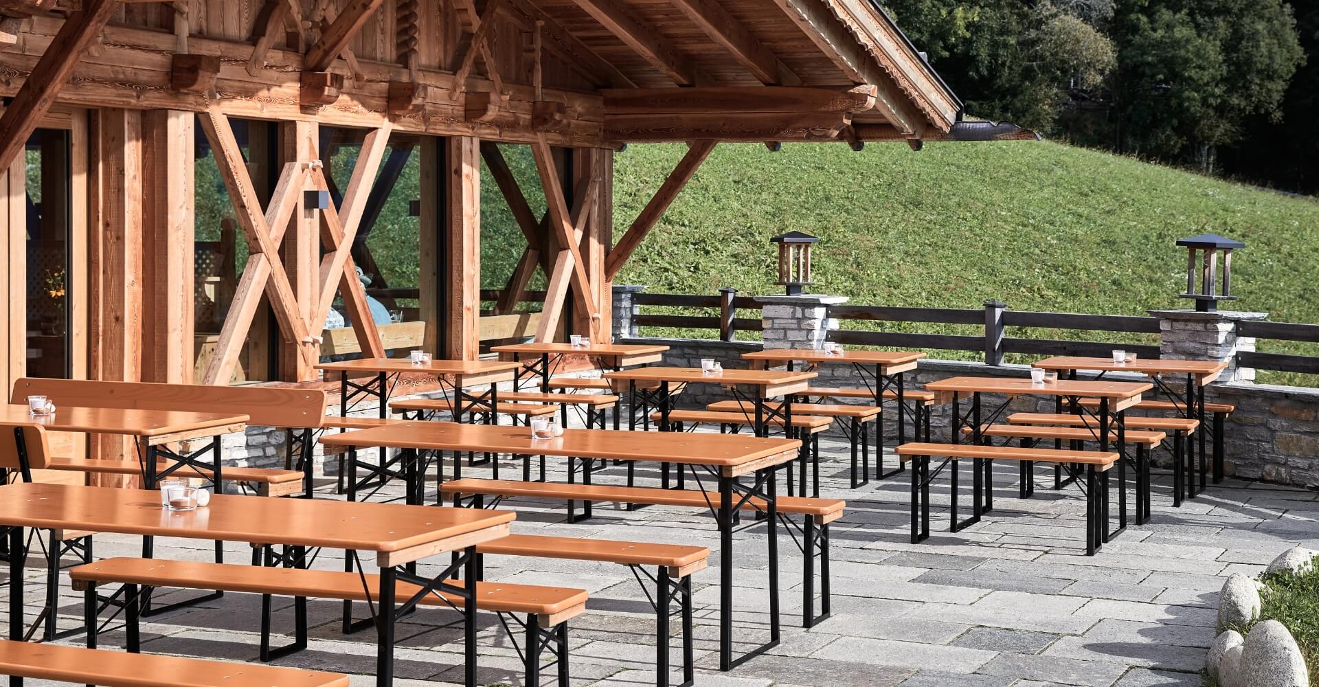 Beer garden table sets stand on the terrace of the cottage. Beer garden table sets on the terrace of the cottage